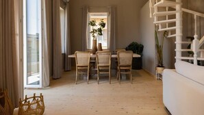 Ein Essbereich mit Tisch und Stühlen, eine Treppe und ein Blick durch eine Glastür.