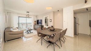 A modern living room with a dining area, a sofa, and a TV. - Enchanting 2 Bedroom In Best Location/Parking (Jerusalem)