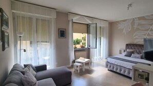 Un dormitorio moderno con cama, televisor y sofá.