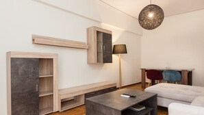 Uma sala de estar moderna com um sofá, uma mesa de centro, uma luminária e estantes embutidas.