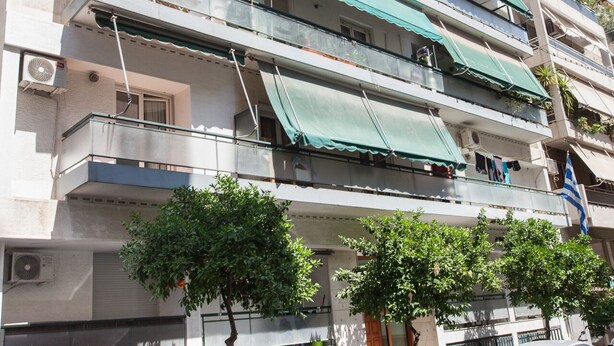 Um edifício de vários andares com varandas e toldos.