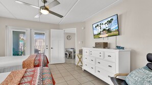 A bedroom with a bed, a dresser, a television, and a ceiling fan. - Gulf Coast Condominium Unit 4 2 Bedroom Condo by RedAwning (South Padre Island)