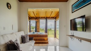 A modern living room with a sofa, a TV, and a hot tub. - Bangalos Luz da Lagoa (Imbituba)