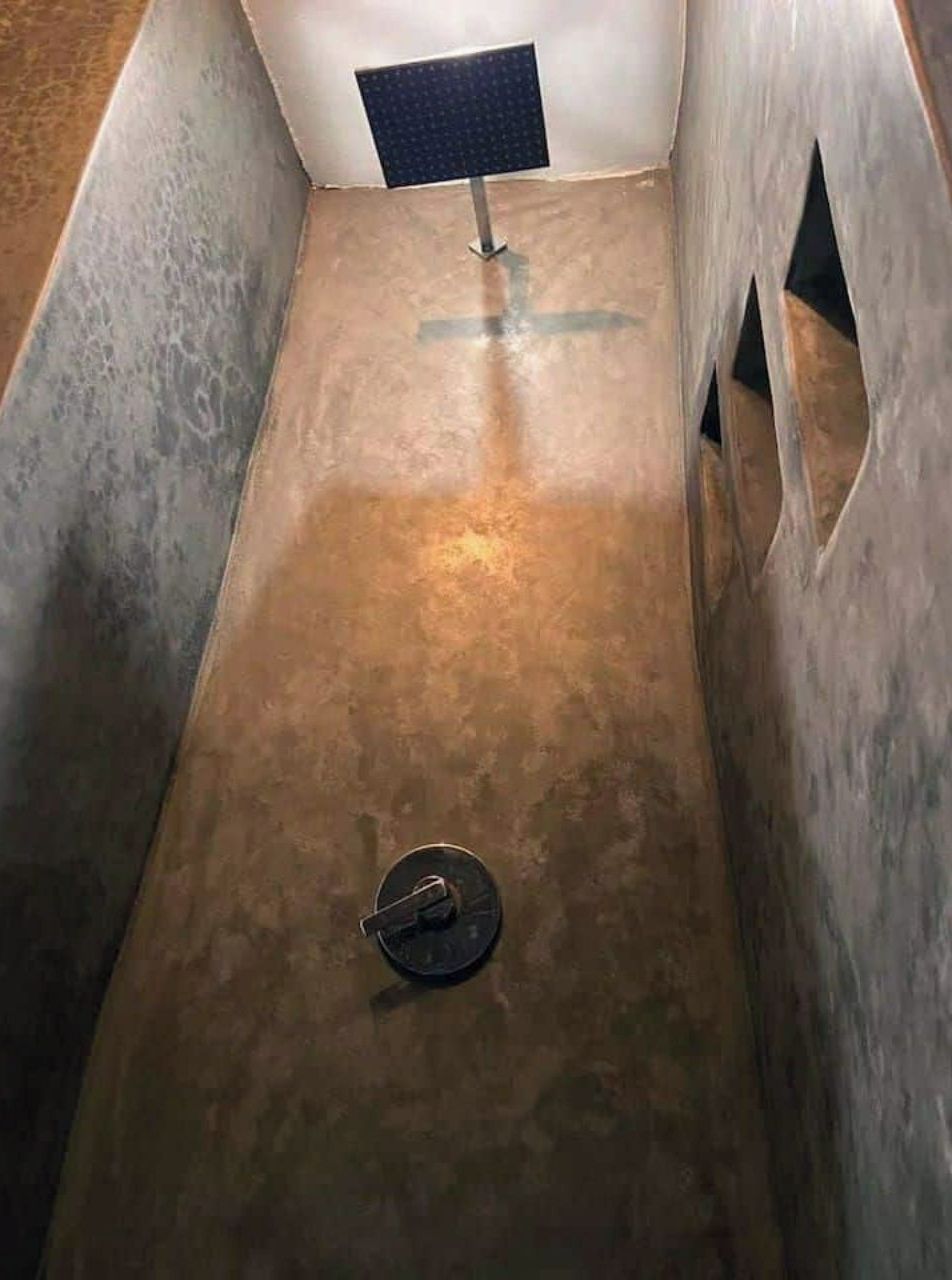 Un espace étroit et clos, avec une porte métallique en bas et un panneau solaire fixé au mur.