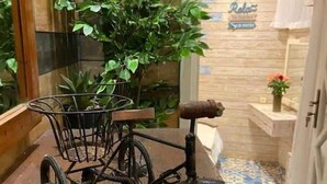 A vintage bicycle with a basket and a seat, placed on a wooden floor with a patterned tile design. - Casa Caméléon (Essaouira)