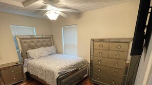 A bedroom with a bed, a dresser, a ceiling fan, and a TV. - Central Columbus Home sure to fit all of your needs. (Columbus)