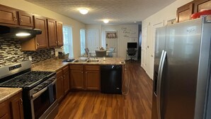 A kitchen with wooden cabinets, a stainless steel refrigerator, and a dishwasher. - Central Columbus Home sure to fit all of your needs. (Columbus)