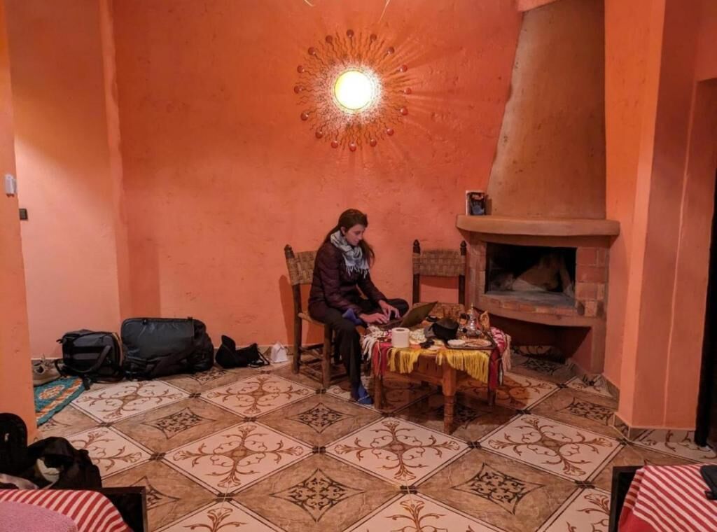 Una habitación con suelo de baldosas, chimenea y una mesa con mantel.