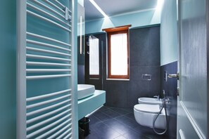 Une salle de bain moderne équipée de toilettes, d’un lavabo et d’une douche.