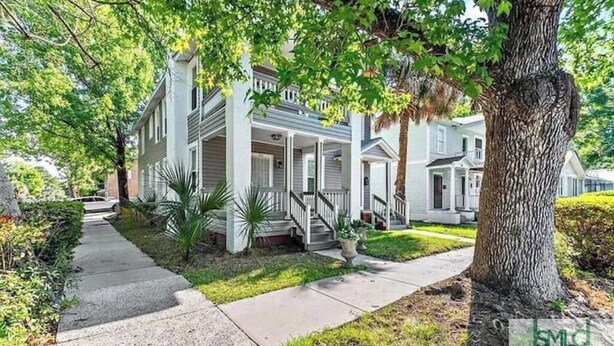 A two-story house with a front porch, a driveway, and a large tree in the foreground. - Luxury Historic Charm 1 mile to Forsyth Park (Savannah)