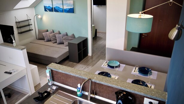 Un apartamento moderno con sala de estar, kitchenette y comedor.