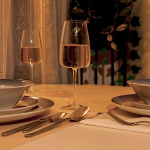 A beautifully set table for two, complete with fine china and wine glasses.
