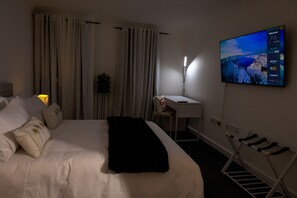 Relax in a spacious room with a large bed, desk, and flat-screen TV.