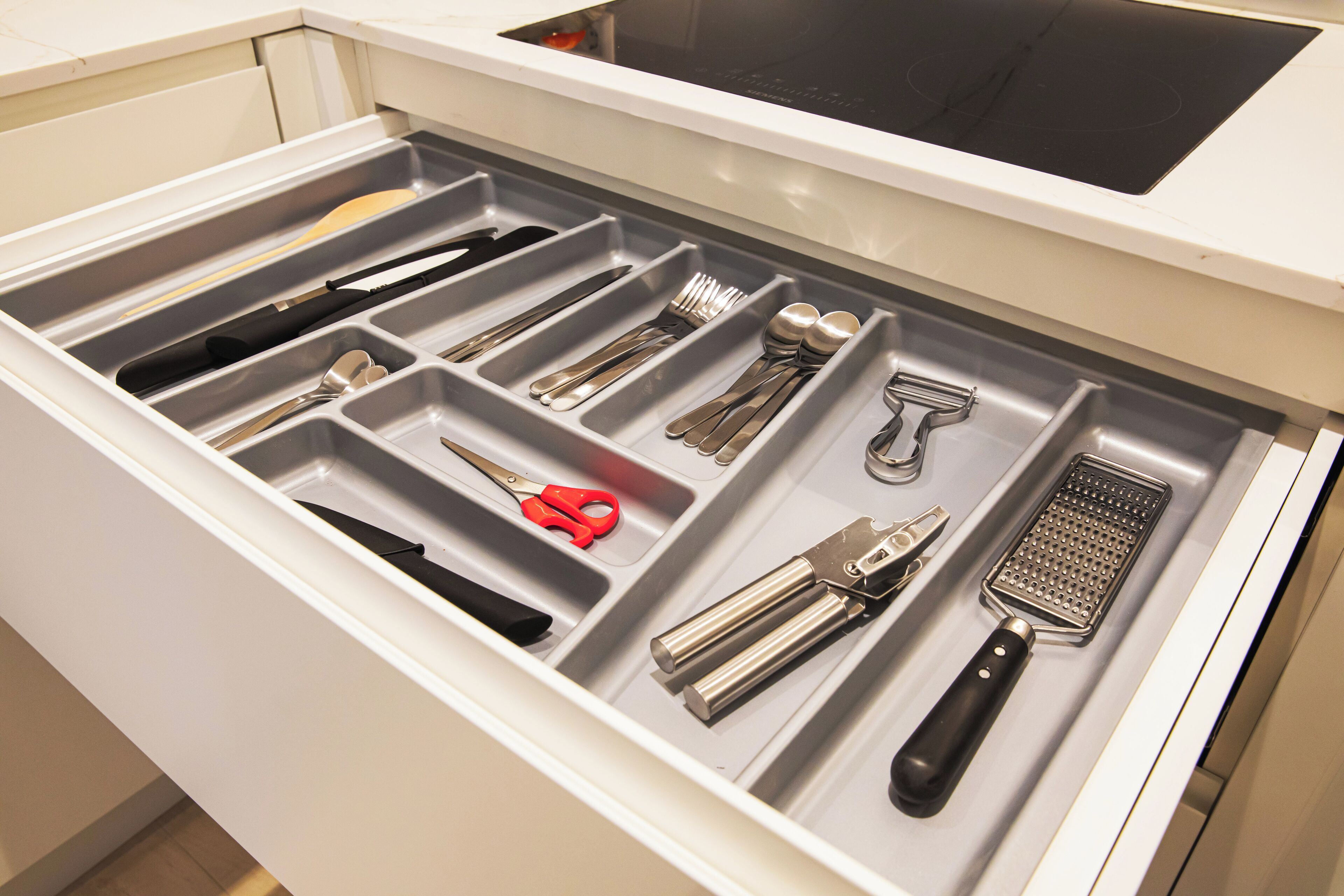 Un cajón de cocina con utensilios y herramientas.