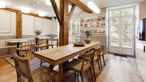 Une pièce spacieuse comprenant une table à manger en bois, des chaises, un canapé et une bibliothèque.