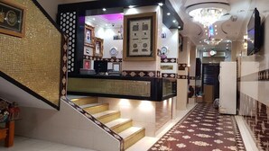 A hotel lobby with a staircase, a reception desk, and a chandelier. - RAHAB HOTEL (Dubai)