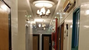 A hotel corridor with a shiny tiled floor, a ceiling with recessed lighting, and doors on both sides. - RAHAB HOTEL (Dubai)