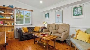 A living room with a sofa, a coffee table, and a bookshelf.