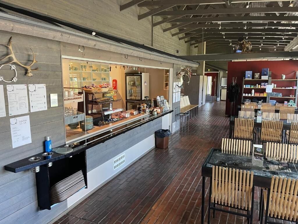 Un restaurante con una barra larga, sillas de madera y suelo de ladrillo.