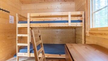 A wooden bunk bed with a ladder, a window, and a wooden floor.