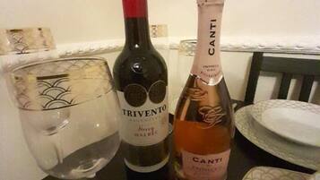 Une table avec deux bouteilles de vin, un verre et des couverts.