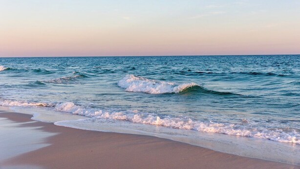 Ein Strand mit sanft brandenden Wellen.