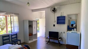 A room with a bed, a chair, a desk, a television, and a fan. - Villa Bella do Turvo Pousada Gastrobar (Andrelandia)