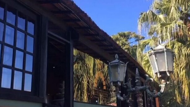 A building with a brick facade, a large window, and a traditional lantern. - Villa Bella do Turvo Pousada Gastrobar (Andrelandia)