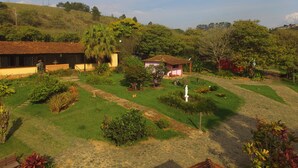 A rural landscape with a house, a small garden, and a statue. - Villa Bella do Turvo Pousada Gastrobar (Andrelandia)