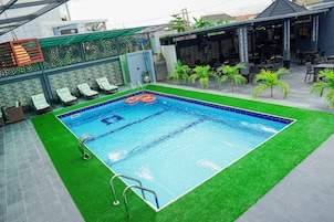 Una piscina al aire libre, sillones reclinables de piscina