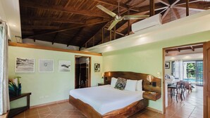 A bedroom with a wooden bed, a ceiling fan, and a view of a patio.