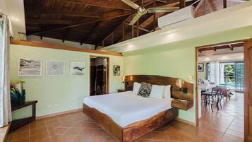 Une chambre avec un lit en bois, un ventilateur de plafond et une vue sur un patio.