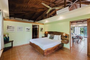 A bedroom with a wooden bed, a ceiling fan, and a view of a patio.