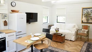 A compact kitchen with a refrigerator, stove, and dining area.
