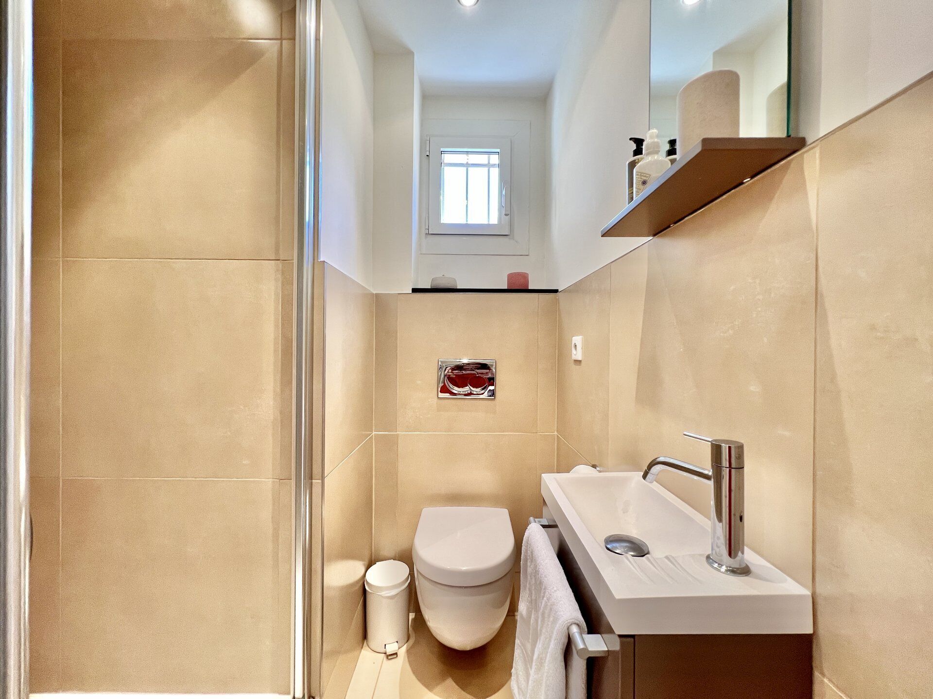 A modern bathroom with a shower, toilet, and sink.