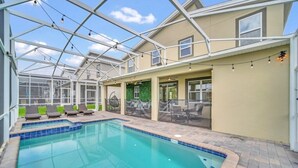 A swimming pool with lounge chairs, a greenhouse structure, and a patio area with outdoor seating. - Luxury 6 Bedroom 5 Bathroom Gated Resort Villa Close to Disney (Davenport)