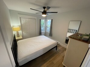 Cozy retreat with a single bed, ceiling fan, and bedside workspace.