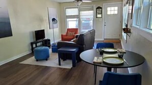 A living room with a sofa, ottoman, and a dining table with chairs. - Pet friendly!  Close to Temple hospitals. (Temple)