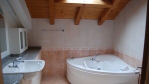 Een badkamer met een vrijstaand bad, een wastafel en een toilet.