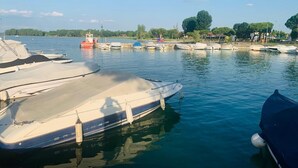 Ein Yachthafen mit mehreren angedockten Booten, ruhigem Wasser und blauem Himmel.