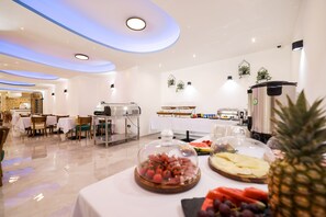 A modern hotel dining area with tables covered in white tablecloths, a coffee station, and a buffet with various food items. - Hotel Kanjon Zrmanje (Obrovac)