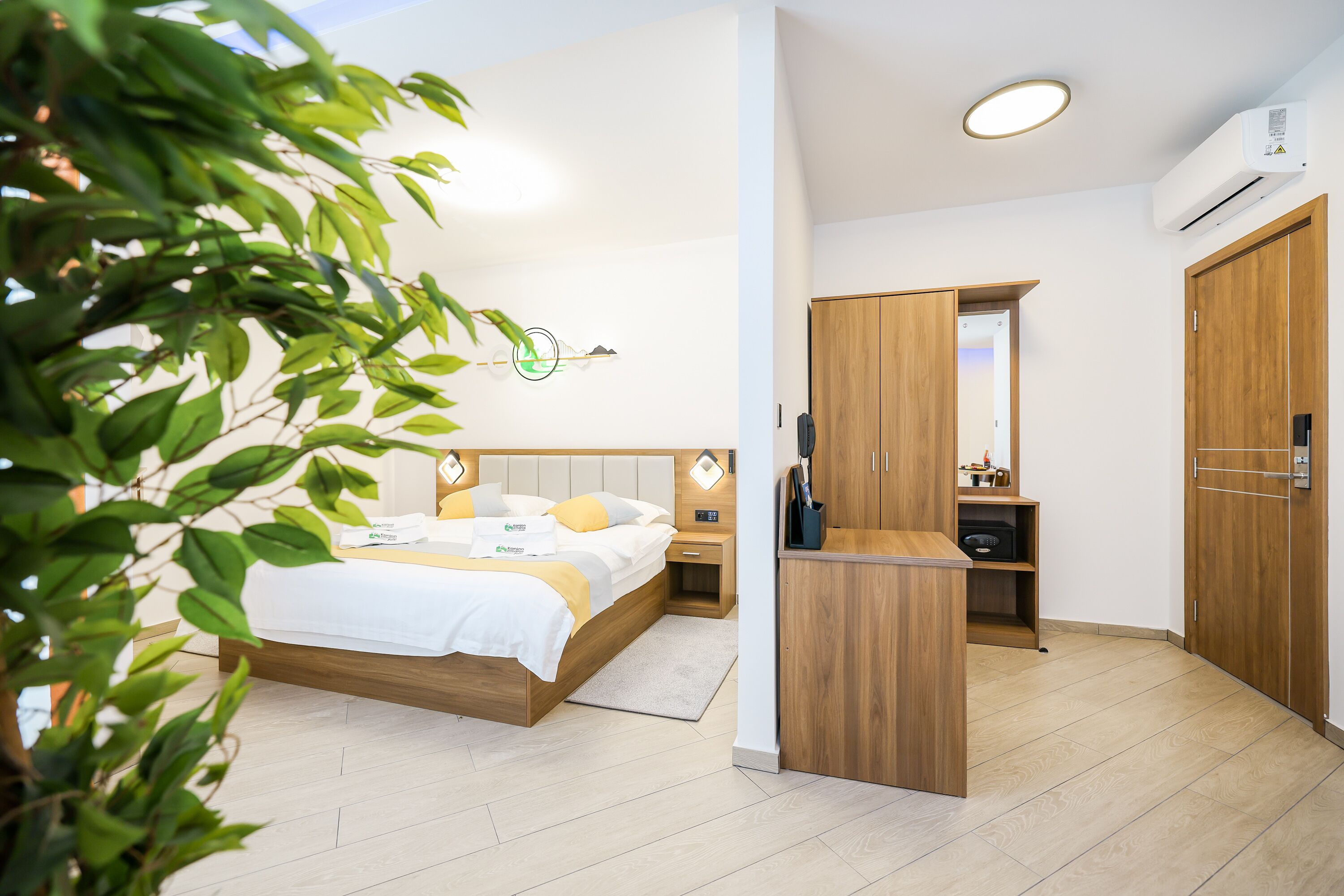 A modern bedroom with a bed, bedside table, wardrobe, and a mirror.