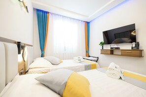 A hotel room with two beds, a TV, a desk with a computer, and a window with curtains. - Hotel Kanjon Zrmanje (Obrovac)