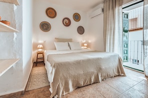 Un dormitorio con cama, lámparas de noche, un tapete y decoración en la pared.