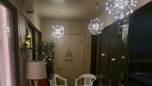 A narrow corridor with a ceiling light fixture, a small table with a chair, and a trash bin. - Beach Retreat w/ Pool & Fishing Dock (Port Charlotte)