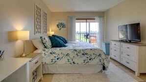 A bedroom with a bed, a TV, a desk, and a window with a view. - Beach Retreat w/ Pool & Fishing Dock (Port Charlotte)