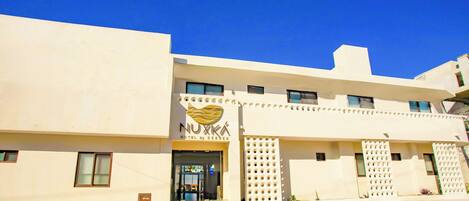 A hotel with a modern facade, a prominent logo, and a clear entrance.