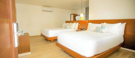 Habitación de hotel con dos camas, cabecera de madera, mesita de noche con lámpara y aire acondicionado instalado en la pared.