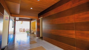 A hallway with wooden panel walls and a tiled floor. - Hotel Yuhome Telchac (Telchac Puerto)