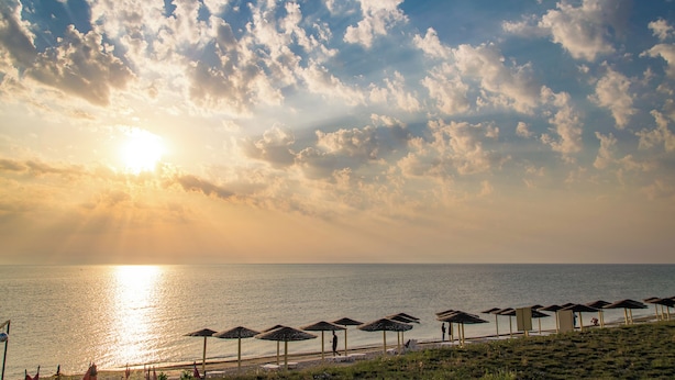 A beach with umbrellas and a clear sky. - Spot Vama Veche (Limanu)